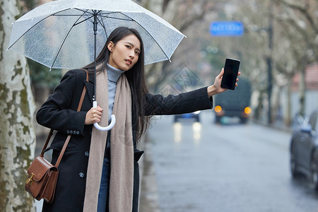 拦车杆下雨天在路边着急拦车的女性背景