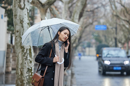 美女走路下雨天在路边着急等车的女性背景