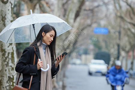 呼叫素材下雨天在路边着急等车的女性背景