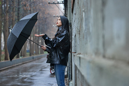 屋檐下躲雨的女性背景图片