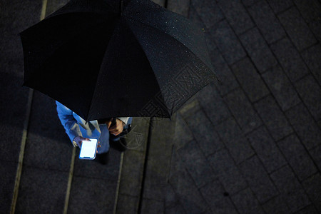 俯视雨伞撑着伞使用手机的人俯视视角背景