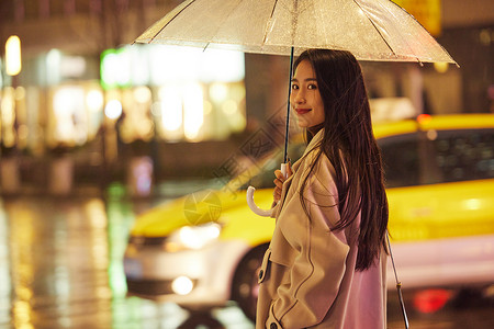 下雨夜晚撑伞走路的女性高清图片