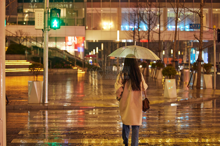 下雨天过马路的女性背影图片