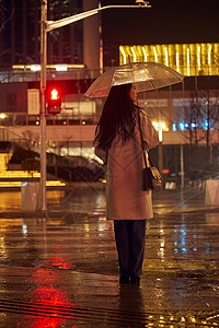 下雨天撑伞等红绿灯的女性背影高清图片