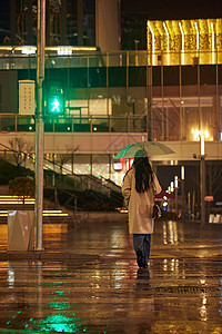 下雨天过马路的女性背影背景图片