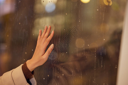 下雨天窗前女性手部特写高清图片