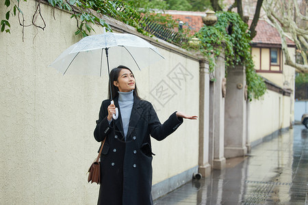 雨天撑伞的女性用手接雨水背景