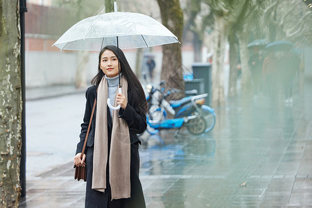 沙尘天气逆风行走下雨天在城市里行走的女性背景