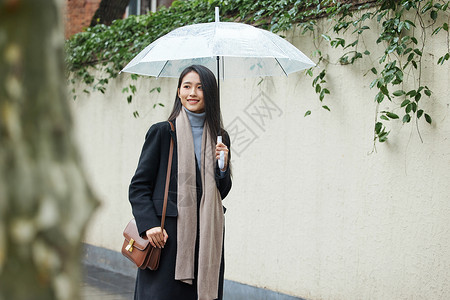 沙尘天气逆风行走下雨天在城市里行走的女性背景