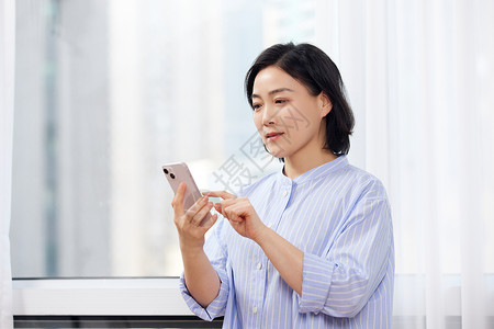 中年女性居家看手机背景图片