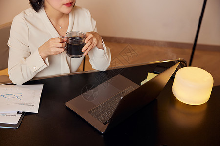 中年商务女性夜晚加班喝咖啡背景图片