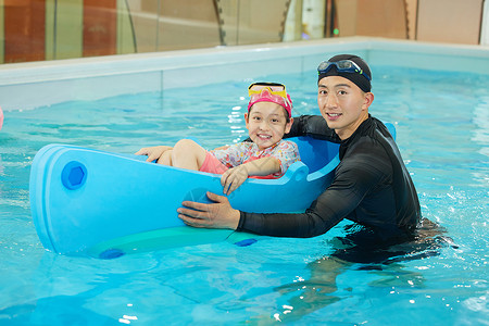 游泳教练带小女孩体验水上设施背景