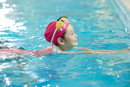 小女孩在泳池游泳背景图片