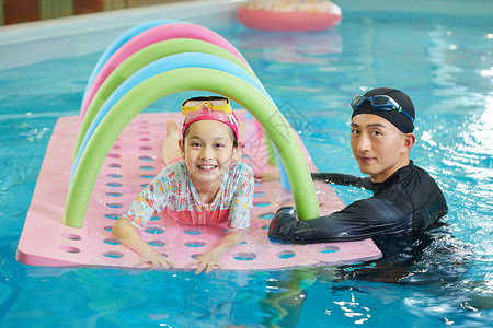 游泳教练带小女孩体验水上设施背景