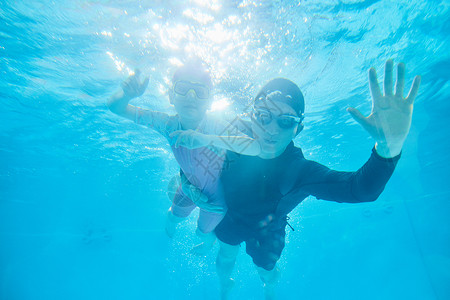儿童游泳优惠券教练带领学员潜水游泳背景