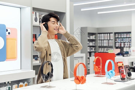 数码产品店选购耳机的帅哥图片