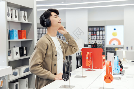 数码产品店选购耳机的帅哥图片