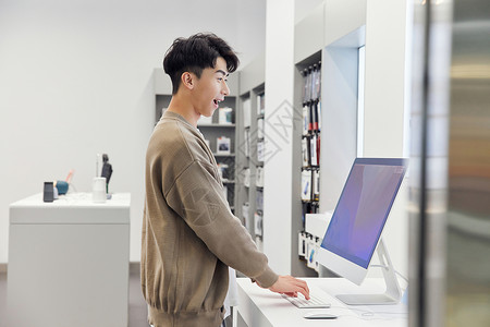 门店日常工作标数码店选购电脑的年轻男性背景