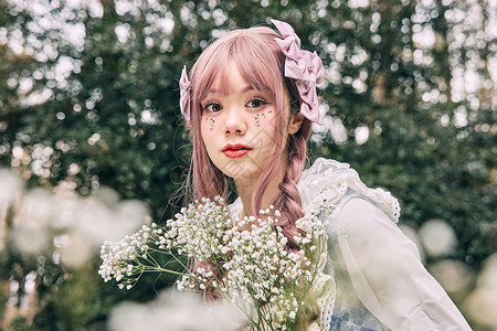 手捧鲜花坐在窗前的洛丽塔女孩手捧鲜花的可爱洛丽塔少女背景