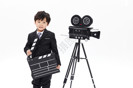 录像机旁的小男孩手拿场记板背景图片