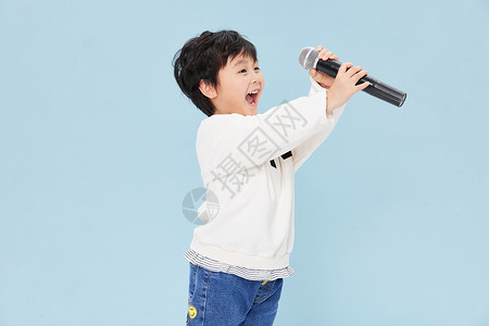 男孩练打拳拿话筒放声唱歌的小男孩背景