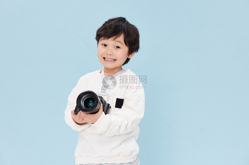 拿相机学习摄影的小男孩图片