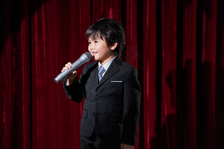 台上男孩舞台上的小主持人手拿话筒背景
