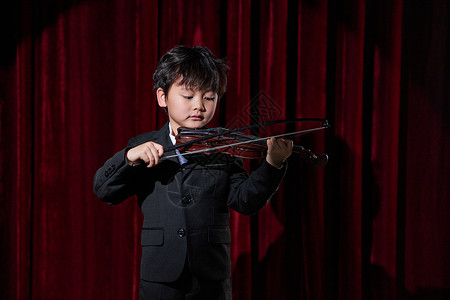 演奏小男孩舞台上演奏小提琴的小男孩背景