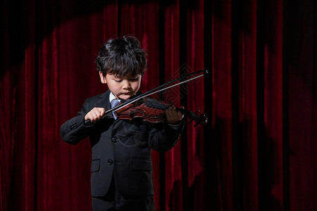 小提琴演奏会舞台上演奏小提琴的小男孩背景