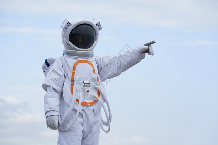 宇航员手户外穿着宇航服的宇航员指远方背景