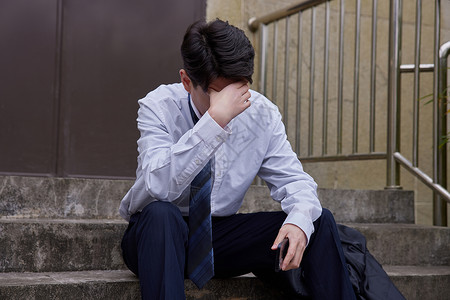 中年男性职场压力掩面思考图片