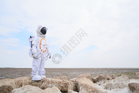 海滩边穿着宇航服的男性图片