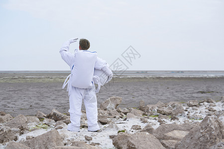 太空实验室穿着宇航服的男性背影背景