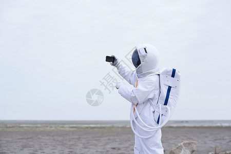 穿着宇航服的男性看手机直播背景图片