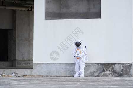 航天人废弃楼中穿着宇航服的男性背景