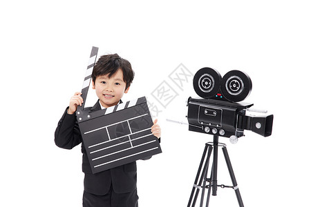 黑色场记板相机旁的小男孩手拿场记板背景
