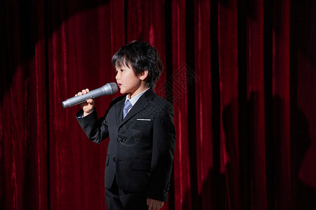 小孩拿话筒舞台上演讲的小主持人背景