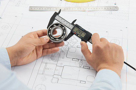 建筑图工程师使用工具测量图纸背景