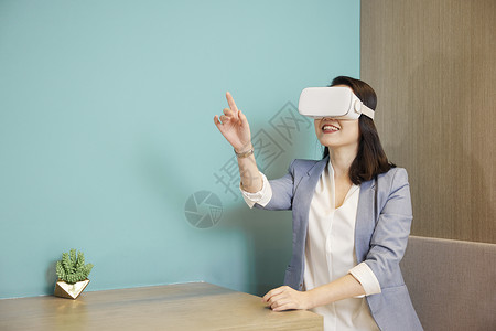 商务女性使用VR眼镜触碰虚拟屏幕背景图片