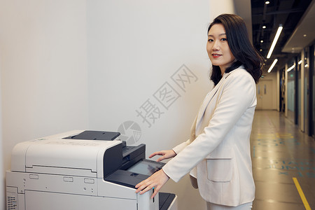 使用打印机的商务白领女性背景图片