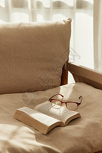 阳光下卧室里的书籍和眼镜背景图片