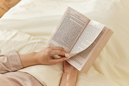 居家女性卧床看书背景图片