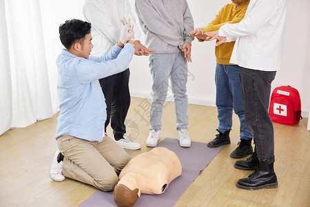 白衣男孩示范心脏复苏急救课程的男老师背景