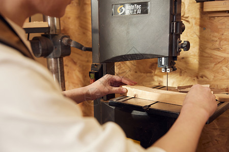 男性工匠使用切割木块特写图片