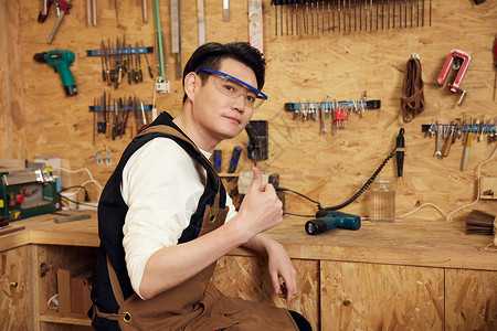 在工作台打磨木具的男性工匠图片