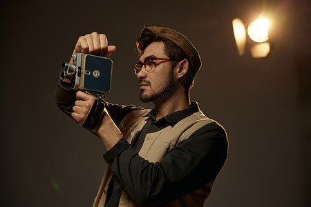 冲洗眼镜手持摄影机录像的文艺男青年背景
