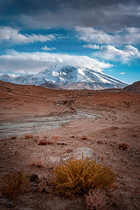 戈壁高原新疆帕米尔高原戈壁河慕士塔格峰雪山背景