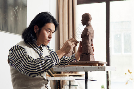 年轻男性雕刻泥塑作品背景图片
