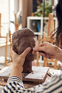 男艺术家雕刻泥塑作品特写图片