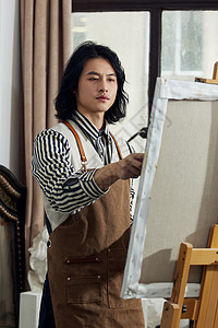 油画工作室里创作的青年画家背景